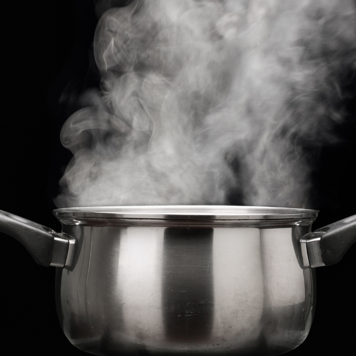 Kjele med kokende vann og vanndamp